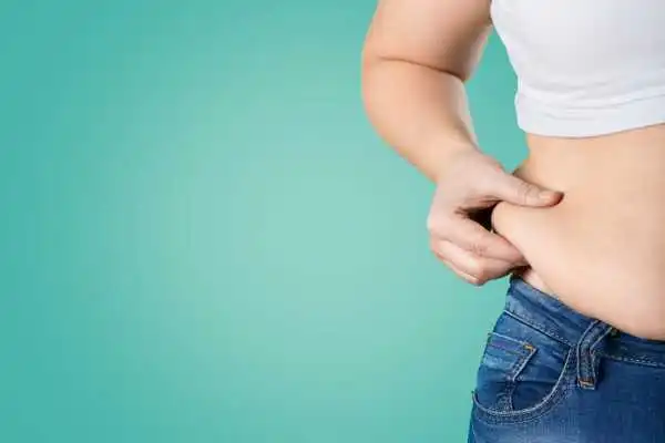 Image of woman pinching her love handles to show weight gain Bristol 
